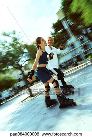 Stock Photo - Mature woman and young girl in line skating, blurred.. Fotosearch