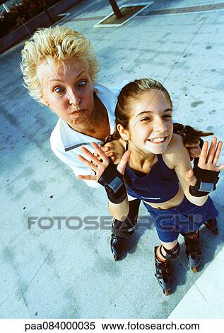 Mature woman and young girl on in-line skates, making faces at camera, high angle view View Large Photo Image Stock Photography - Mature woman and young girl on in-line skates, making faces at camera, high angle view. Fotosearch