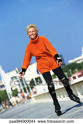 Mature woman in-line skating on boardwalk. View Large Photo Image Picture - Mature woman in-line skating on boardwalk.. Fotosearch