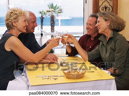 Two mature couples clinking glasses, side view View Large Photo Image Stock Image - Two mature couples clinking glasses, side view. Fotosearch