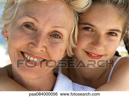 Stock Photograph - Young girl hugging mature woman from behind, close up, portrait.. Fotosearch
