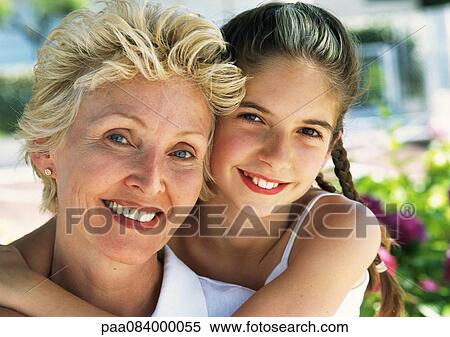 Stock Photography - Young girl hugging mature woman from behind, portrait.. Fotosearch