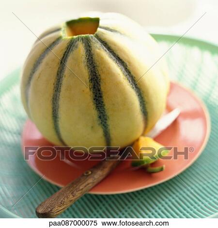 Stock Photography - Close-up of cantaloupe on plate with knife.. Fotosearch