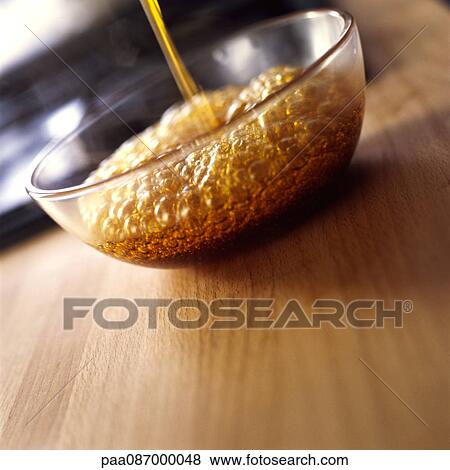 Stock Photo - Close-up of caramel being poured into mixing bowl.. Fotosearch