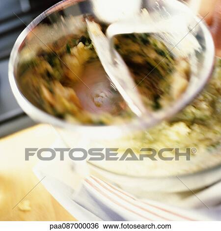 Stock Photograph - Close-up of food being mashed in foodmill, blurry.. Fotosearch