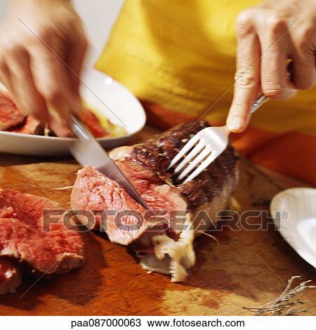 Close-up of hands cutting roast beef View Large Photo Image Stock Image - Close-up of hands cutting roast beef. Fotosearch