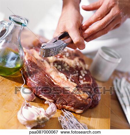 Close-up of meat being prepared with crushed garlic. View Large Photo Image Stock Photo - Close-up of meat being prepared with crushed garlic.. Fotosearch