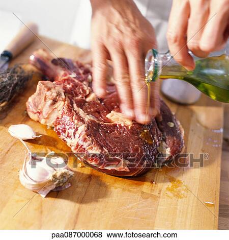 Close-up of meat being prepared with oil. View Large Photo Image Stock Photo - Close-up of meat being prepared with oil.. Fotosearch