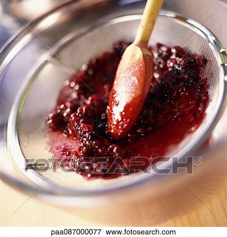 Close-up of wooden spoon pressing raspberries in a strainer. View Large Photo Image Stock Photo - Close-up of wooden spoon pressing raspberries in a strainer.. Fotosearch