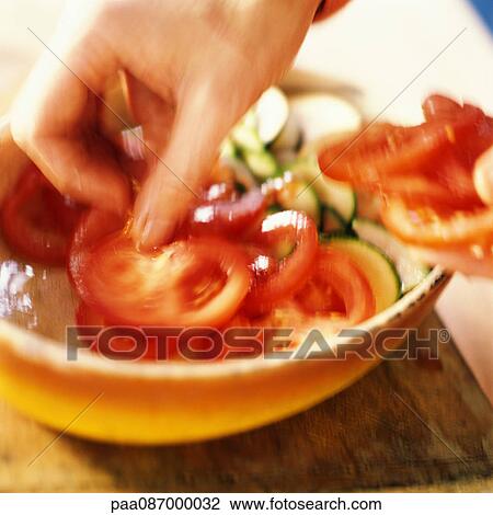 Hand placing tomato slices in bowl, close-up, blurry. View Large Photo Image Stock Image - Hand placing tomato slices in bowl, close-up, blurry.. Fotosearch
