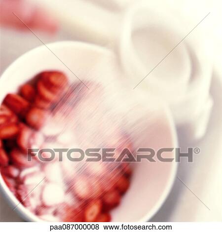 Stock Photo - Strawberries being sprinkled with sugar, blurry.. Fotosearch