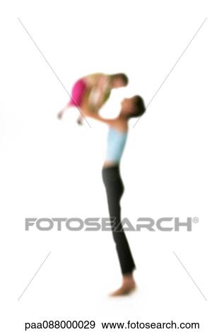 Stock Photo - Silhouette of woman holding up child in air, on white background, defocused. Fotosearch