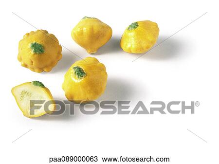 Stock Image - Yellow pattypan squashes, one cut in half. Fotosearch