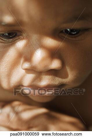 Stock Photo - Baby's face with shadows, close-up. Fotosearch