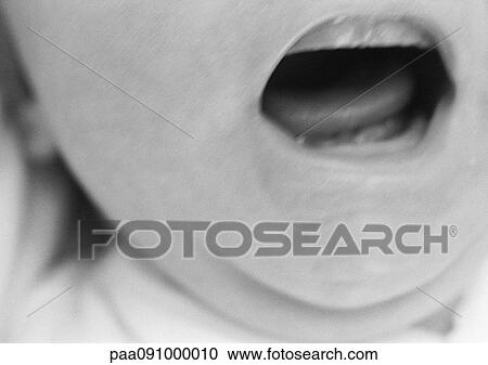 Stock Image - Baby's open mouth, close-up, b&w. Fotosearch