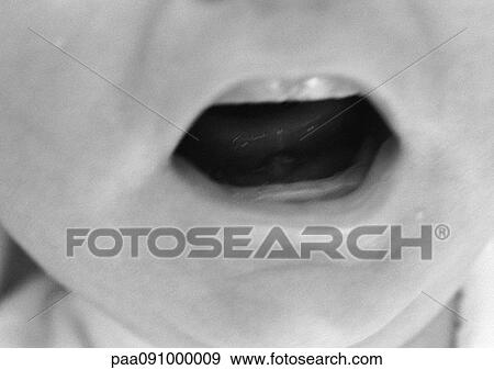Stock Photo - Baby's open mouth, close-up, b&w. Fotosearch