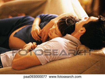 Stock Photo - Man and pregnant woman on sofa, high angle view. Fotosearch