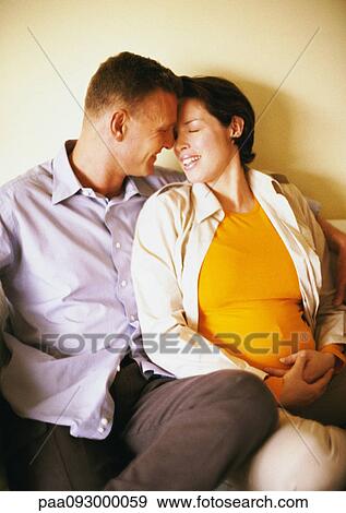 Man and pregnant woman sitting and smiling at each other View Large Photo Image Stock Photo - Man and pregnant woman sitting and smiling at each other. Fotosearch
