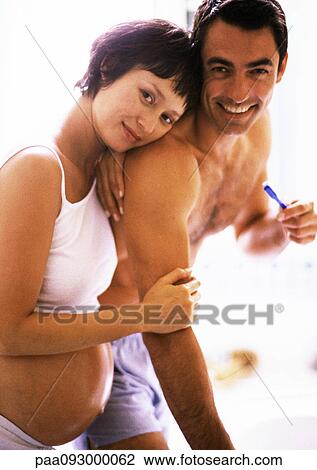 Man brushing teeth in bathroom, pregnant woman leaning on his shoulder View Large Photo Image Stock Image - Man brushing teeth in bathroom, pregnant woman leaning on his shoulder. Fotosearch