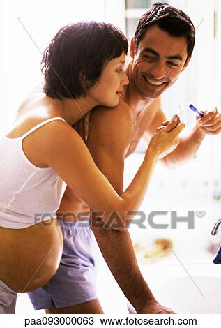 Man brushing teeth in bathroom, pregnant woman leaning on his shoulder View Large Photo Image Stock Image - Man brushing teeth in bathroom, pregnant woman leaning on his shoulder. Fotosearch