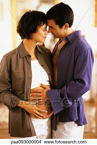 Man hugging pregnant woman, both with hands on her belly, portrait View Large Photo Image Picture - Man hugging pregnant woman, both with hands on her belly, portrait. Fotosearch