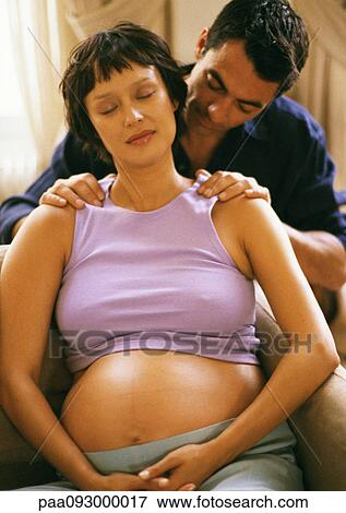 Stock Photo - Man massaging pregnant woman's shoulders. Fotosearch