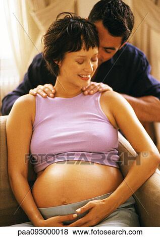 Stock Photo - Man massaging pregnant woman's shoulders. Fotosearch