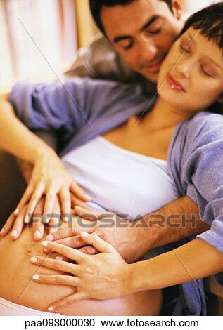 Man touching pregnant woman's stomach from behind View Large Photo Image Stock Image - Man touching pregnant woman's stomach from behind. Fotosearch