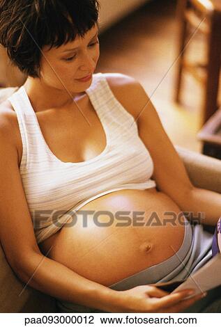 Pregnant woman reading in armchair, high angle view View Large Photo Image Stock Image - Pregnant woman reading in armchair, high angle view. Fotosearch