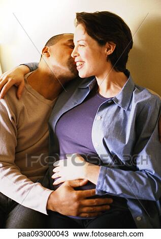 Pregnant woman sitting with arm around man, portrait View Large Photo Image Stock Image - Pregnant woman sitting with arm around man, portrait. Fotosearch