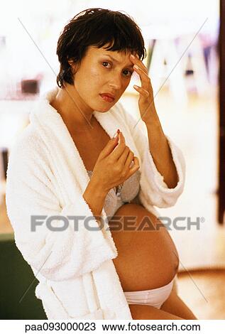 Pregnant woman touching her forehead and holding pill, portrait View Large Photo Image Stock Image - Pregnant woman touching her forehead and holding pill, portrait. Fotosearch