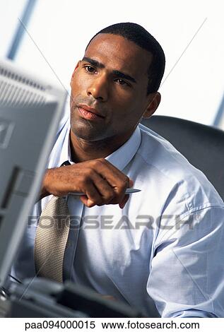 Stock Photography - Businessman looking at computer monitor. Fotosearch