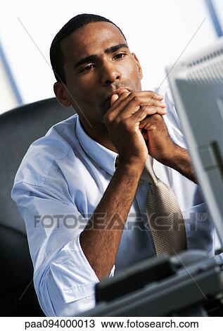 Stock Image - Businessman looking at computer. Fotosearch