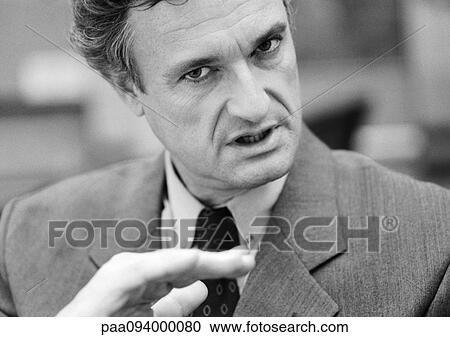 Stock Image - Businessman making gesture with hand and looking at camera, close-up, portrait, B&W. Fotosearch