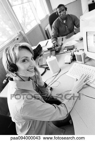 Businesswoman and colleague wearing headsets, B&W View Large Photo Image Stock Image - Businesswoman and colleague wearing headsets, B&W. Fotosearch
