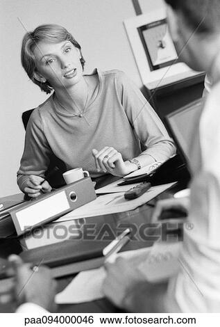 Businesswoman listening to colleague, B&W View Large Photo Image Stock Photograph - Businesswoman listening to colleague, B&W. Fotosearch