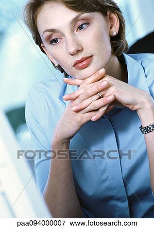 Stock Photo - Businesswoman with hands clasped under chin, close-up. Fotosearch