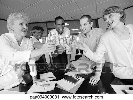 Stock Image - Group of business people clinking glasses in conference room, B&W. Fotosearch