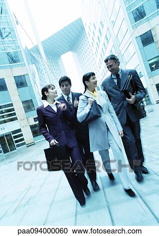 Stock Image - Group of business people walking outdoors. Fotosearch