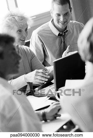 Mature businesswoman in conference, using laptop, with other business people, B&W View Large Photo Image Stock Image - Mature businesswoman in conference, using laptop, with other business people, B&W. Fotosearch
