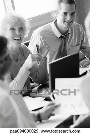 Mature businesswoman in conference, smiling, with other businesspeople, B&W View Large Photo Image Stock Photo - Mature businesswoman in conference, smiling, with other businesspeople, B&W. Fotosearch