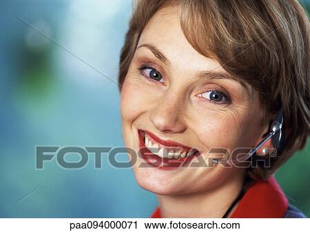 Woman wearing headset, smiling at camera, close-up, portrait View Large Photo Image Stock Image - Woman wearing headset, smiling at camera, close-up, portrait. Fotosearch