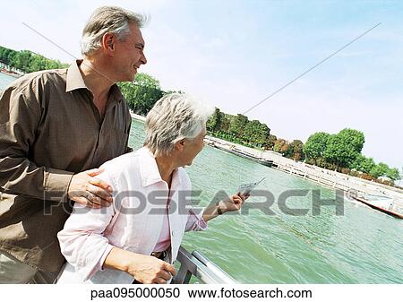 Stock Image - France, Paris, mature man and woman on a boat in the River Seine. Fotosearch