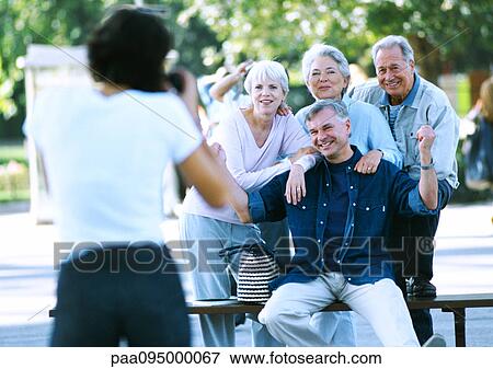 Stock Photo - Group of mature people having their photo taken, blurred foreground. Fotosearch