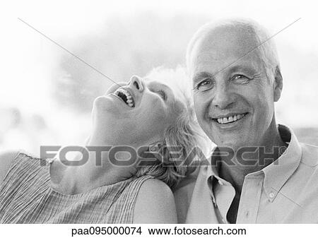 Picture - Mature man and woman smiling, woman with head back, close-up, B&W. Fotosearch