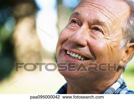 Stock Image - Mature man looking up, close-up, portrait. Fotosearch