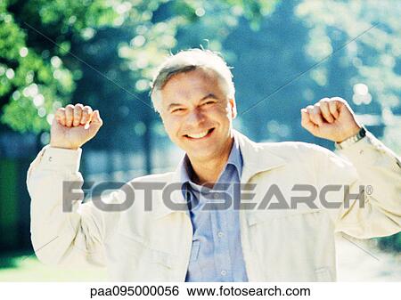 Mature man raising fists, portrait View Large Photo Image Stock Photograph - Mature man raising fists, portrait. Fotosearch