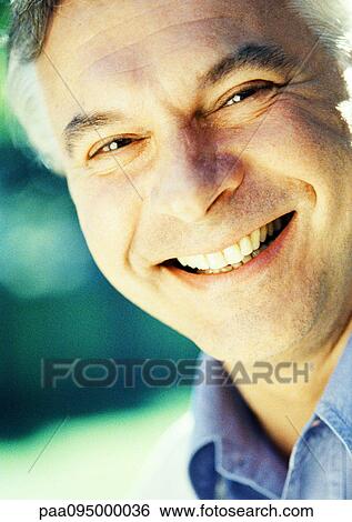 Stock Photograph - Mature man smiling at camera, close-up, portrait. Fotosearch