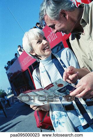 Mature woman and man examining a brochure View Large Photo Image Stock Image - Mature woman and man examining a brochure. Fotosearch