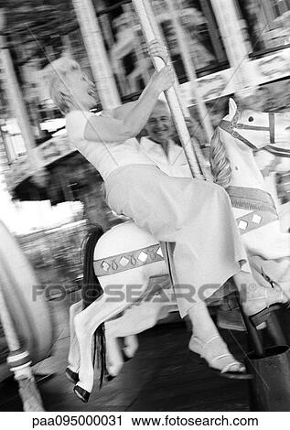 Mature woman laughing on a carousel, B&W View Large Photo Image Stock Image - Mature woman laughing on a carousel, B&W. Fotosearch